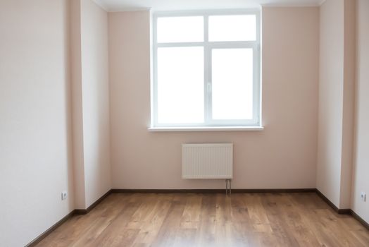 Light empty room with big white isolated window and wooden floor