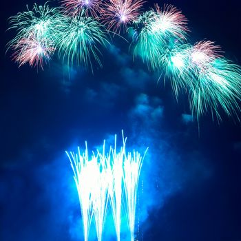 Colorful blue holiday fireworks on the black sky background