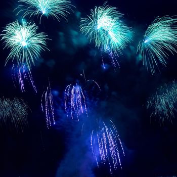 Colorful blue holiday fireworks on the black sky background