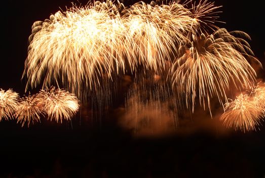 Colorful orange fireworks on the black sky background