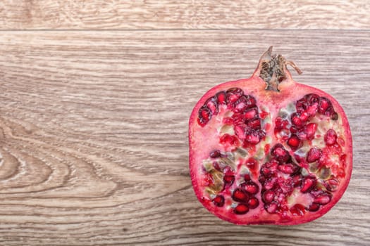 Cut red pomegranate on a wooden background