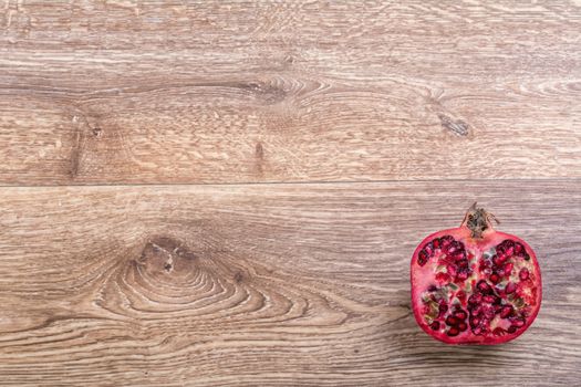 Cut red pomegranate on a wooden background