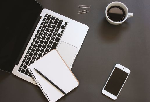 Creative flat lay design of workspace desk with laptop, notebook, smartphone and coffee with copy space background