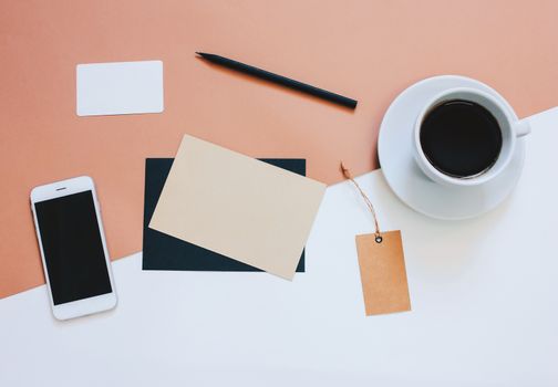 Creative flat lay photo of workspace desk with smartphone, coffee, tag and letter with copy space background, minimal styled
