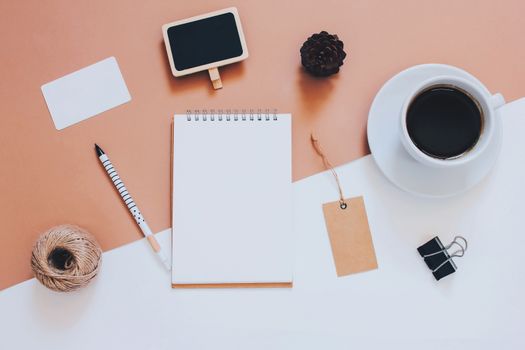 Creative flat lay photo of workspace desk with smartphone, coffee, tag and notebook with copy space background, minimal styled
