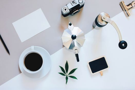 Creative flat lay photo of coffee workspace with coffee maker, coffee grinder, black coffee, film camera, blank card with copy space background, minimal style
