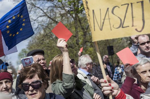 POLAND, Warsaw: A demonstrator holds up a red card during a protest in Warsaw, Poland against the new Police Act and State Surveillance Law on April 16, 2016.The Police Act allows investigators to access specific private information. The new regulations have been set by the parliament where the vast majority of members are from Jarosław Kaczyński's party Law and Justice (PiS).The demonstrators rallied in front of the Chancellery of the Prime Minister