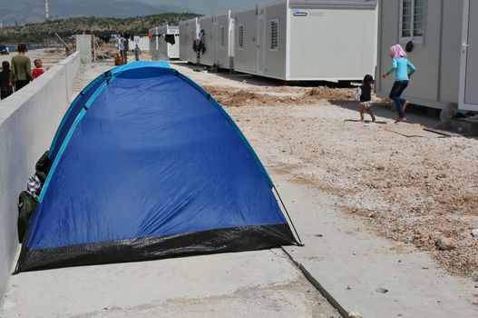 GREECE, Athens: A family has set up its tent next to the family's new home in Skaramagas camp, on  April 14, 2016.