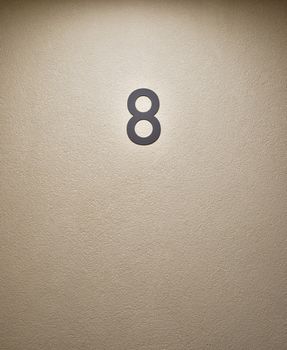 number 8 on stucco wall, new apartment