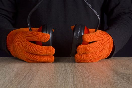 Ear protectors in human hand.  On a wooden surface.