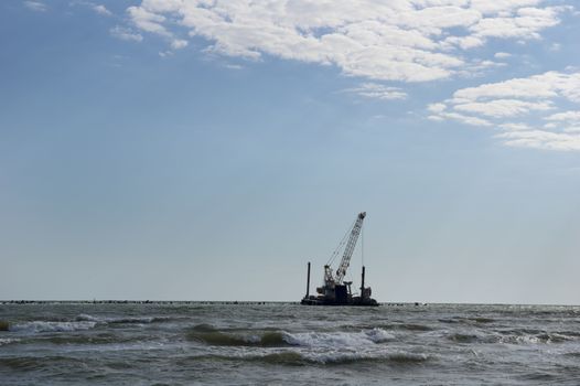 Crane working at the stone breakwater