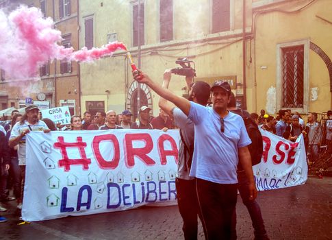 ITALY, Rome: Protesters hold a banner reading Now the house during a demonstration, called by the Movements for the Right to Housing, to protest against forced housing evictions and to ask for the right to housing in Rome, Italy on April 16, 2016. Thousands of 'Housing Rights' activists took to the street in Rome to protest against forced housing evictions, to ask for the respect of accommodation right and use more public funds to help people without homes or those who cannot pay their rent.