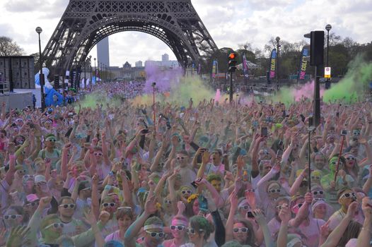 FRANCE, Paris : People participate in the Color Run 2016 in front of the Eiffel Tower in Paris on April 17, 2016.The Color Run is a five kilometres paint race without winners nor prizes, while runners are showered with colored powder at stations along the run. 