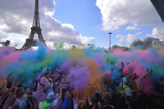 FRANCE, Paris : People participate in the Color Run 2016 in front of the Eiffel Tower in Paris on April 17, 2016.The Color Run is a five kilometres paint race without winners nor prizes, while runners are showered with colored powder at stations along the run. 
