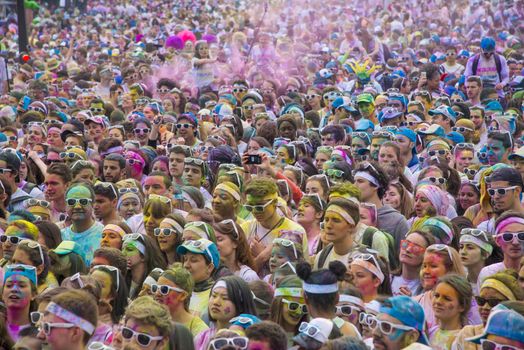 FRANCE, Paris : People participate in the Color Run 2016 in front of the Eiffel Tower in Paris on April 17, 2016. The Color Run is a five kilometres paint race without winners nor prizes, while runners are showered with colored powder at stations along the run. 