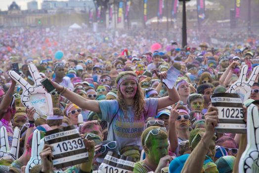 FRANCE, Paris : People participate in the Color Run 2016 in front of the Eiffel Tower in Paris on April 17, 2016. The Color Run is a five kilometres paint race without winners nor prizes, while runners are showered with colored powder at stations along the run. 
