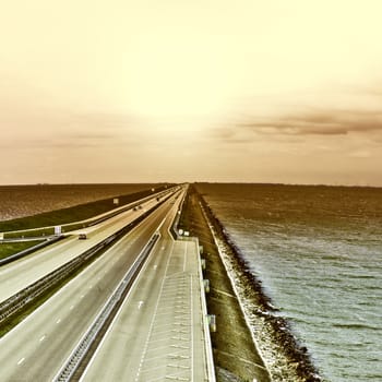 Sunset over Modern Highway on the Protective Dam in Netherlands, Vintage Style Toned Picture