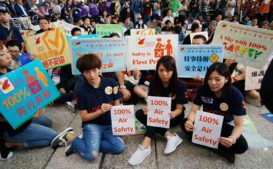 HONG KONG:  Protesters hold signs reading 100% Air Safety during a protest organised by the Hong Kong Cabin Crew Federation at Hong Kong International Airport on April 17, 2016.More than 1,000 people protested at the city's airport on April 17 over an incident that saw the daughter of the city's leader had her forgotten hand baggage delivered to her at the restricted airport area.
