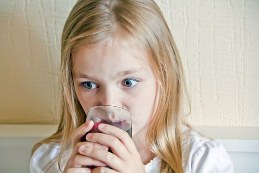 Cute girl with blond long hair drinking beverage