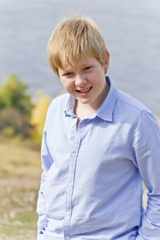 Cute blond boy in autumn yellow forest