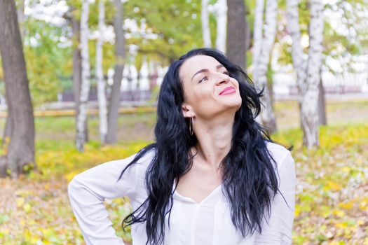 European woman with black hair in autumn park