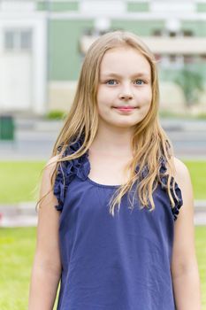 Caucasian cute girl with blond hair in blue dress