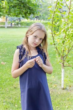 Caucasian cute girl with blond hair in blue dress