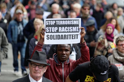 BELGIUM, Brussels : A protester holdsa sign reading 'Stop terrorism, stop racism' as thousands take part in the peaceful march #Tousensemble - #Sameneen against terrorism and hate in the city centre of Brussels on April 17, 2016. At least a thousand people paid a tribute to the victims of the terror attack of March 22 in the streets of Brussels during the peaceful march organised by citizens associations.