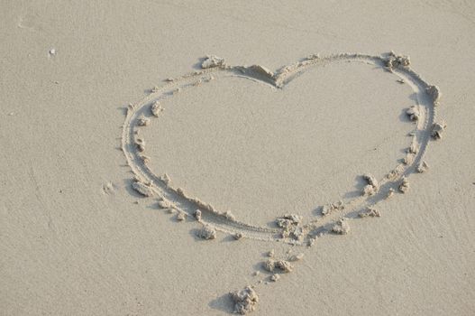 Heart sign of love on sand at beach use as background.