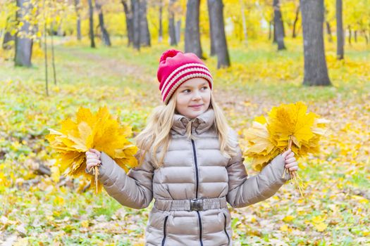 Playing girl with two bouquets from sheets in park
