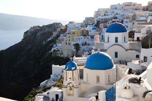 Blue domes and their bell tower in Oia. Santorini
