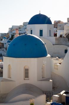Blue domes and their bell tower in Oia. Santorini