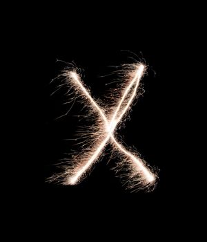 Letter X drew with spakrs on a black background.
