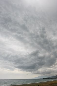 rainstorm, heavy overcast raiclouds over the sea beach