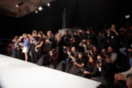 blurred image of group of audience at fashion show stage