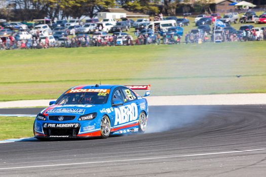 PHILLIP ISLAND, MELBOURNE/AUSTRALIA - 17 APRIL 2016: Nick Percat's Holden Commodore suffers mechanical damage as it exits turn 4 at Phillip Island.