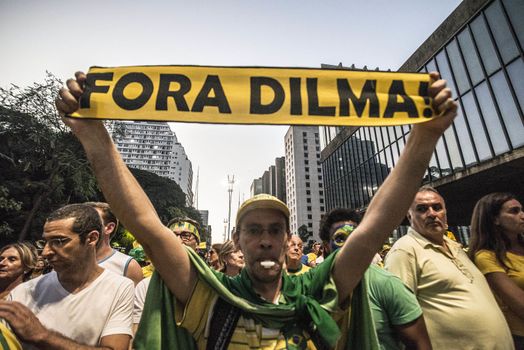 BRAZIl, Sao Paulo: A man holds a placard which reads Dilma out! as thousands of activists supporting the impeachment of President Dilma Rousseff take part in a protest in Sao Paulo, on April 17, 2016. Brazilian lawmakers on Sunday reached the two thirds majority necessary to authorize impeachment proceedings against President Dilma Rousseff. The lower house vote sends Rousseff's case to the Senate, which can vote to open a trial. A two thirds majority in the upper house would eject her from office. Rousseff, whose approval rating has plunged to a dismal 10 percent, faces charges of embellishing public accounts to mask the budget deficit during her 2014 reelection.