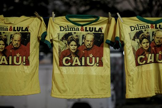BRAZIL, Curitiba: Tee-shirts which read Dropped down with pictures of President Dilma Rousseff and former President Luiz Inacio Lula da Silva are seen as activists supporting the impeachment of Brazilian President Dilma Rousseff follow on a big screen as lawmakers vote on whether the impeachment of Rousseff will move forward, in Curitiba, southern Brazil, on April 17, 2016. Brazilian lawmakers on Sunday reached the two thirds majority necessary to authorize impeachment proceedings against President Dilma Rousseff. The lower house vote sends Rousseff's case to the Senate, which can vote to open a trial. A two thirds majority in the upper house would eject her from office. Rousseff, whose approval rating has plunged to a dismal 10 percent, faces charges of embellishing public accounts to mask the budget deficit during her 2014 reelection.