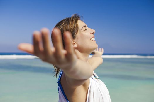 Beautiful woman enjoying the summer with both arms open