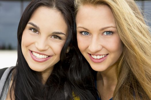 Two beautiful and happy teenage students smiling 