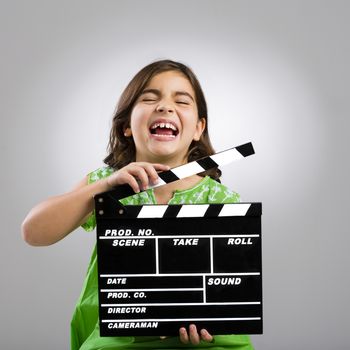 Studio portrait of a little girl playing as a young film director