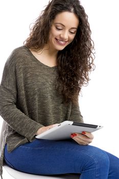 Beautiful and happy girl working with a tablet, isolated over white background 