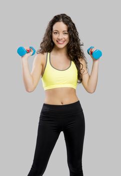 Beautiful sporty woman doing exercises with weights