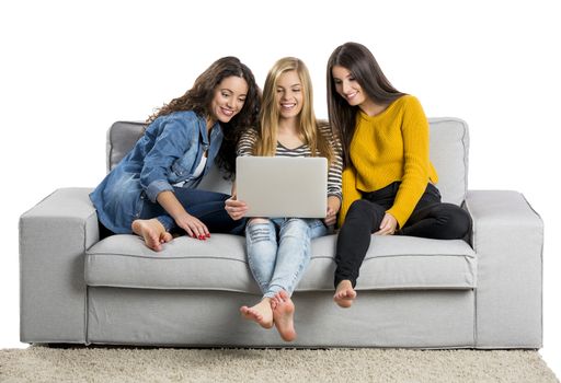 Happy teen girls at home with a laptop