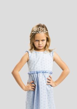 Portrait of a cute little girl with a princess crown making a sad face