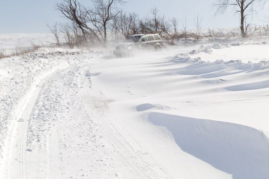 A vehicle driving in blowing drifting snow on a rural road in Pennsylvania, USA.