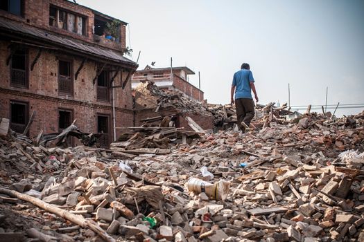 NEPAL,Kathmandu: A man walks on top of the rubble in the Kathmandu Valley in Nepal, on May 25, 2015, after a magnitude 7.8 earthquake hit the area.More than 8,000 people died in the quake and some 3.5 million were left homeless. 