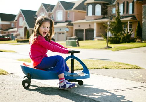 small girl is having fun riding his toy on the street