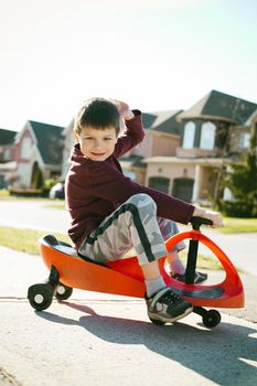 small boy is having fun riding his toy on the street