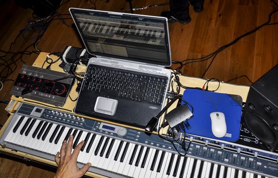 Musician playing on keyboards in a music studio 